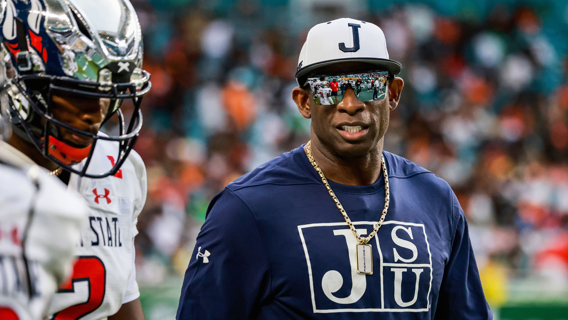 Coach Deion Prime Sanders talks with his son, Shedeur Sanders, Jackson State University Quarterback before the start of the second half of the game against Florida A&M University
