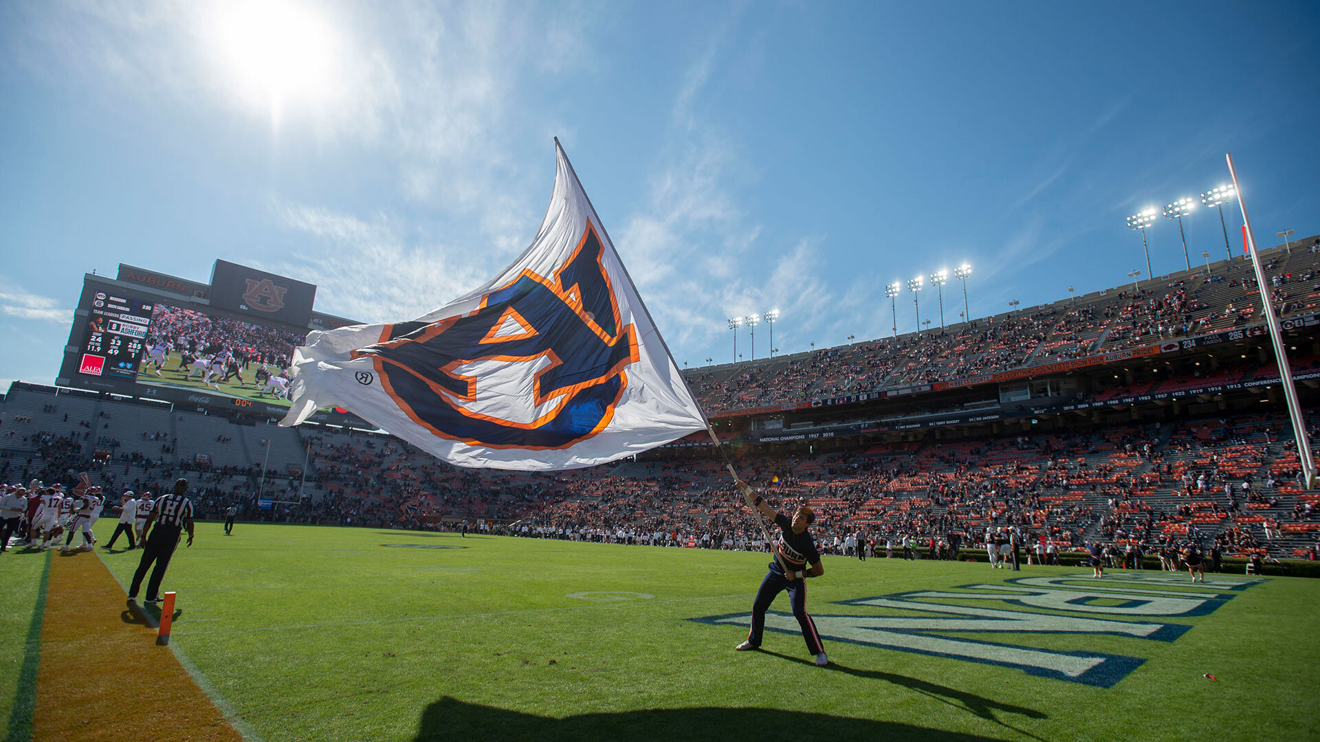 AUBURN, ALABAMA - OCTOBER 29: A cheerleader with the Auburn Tigers waves their flag after a score during their game against the Arkansas Razorbacks at Jordan-Hare Stadium on October 29, 2022 in Auburn, Alabama. (Photo by Michael Chang/Getty Images)