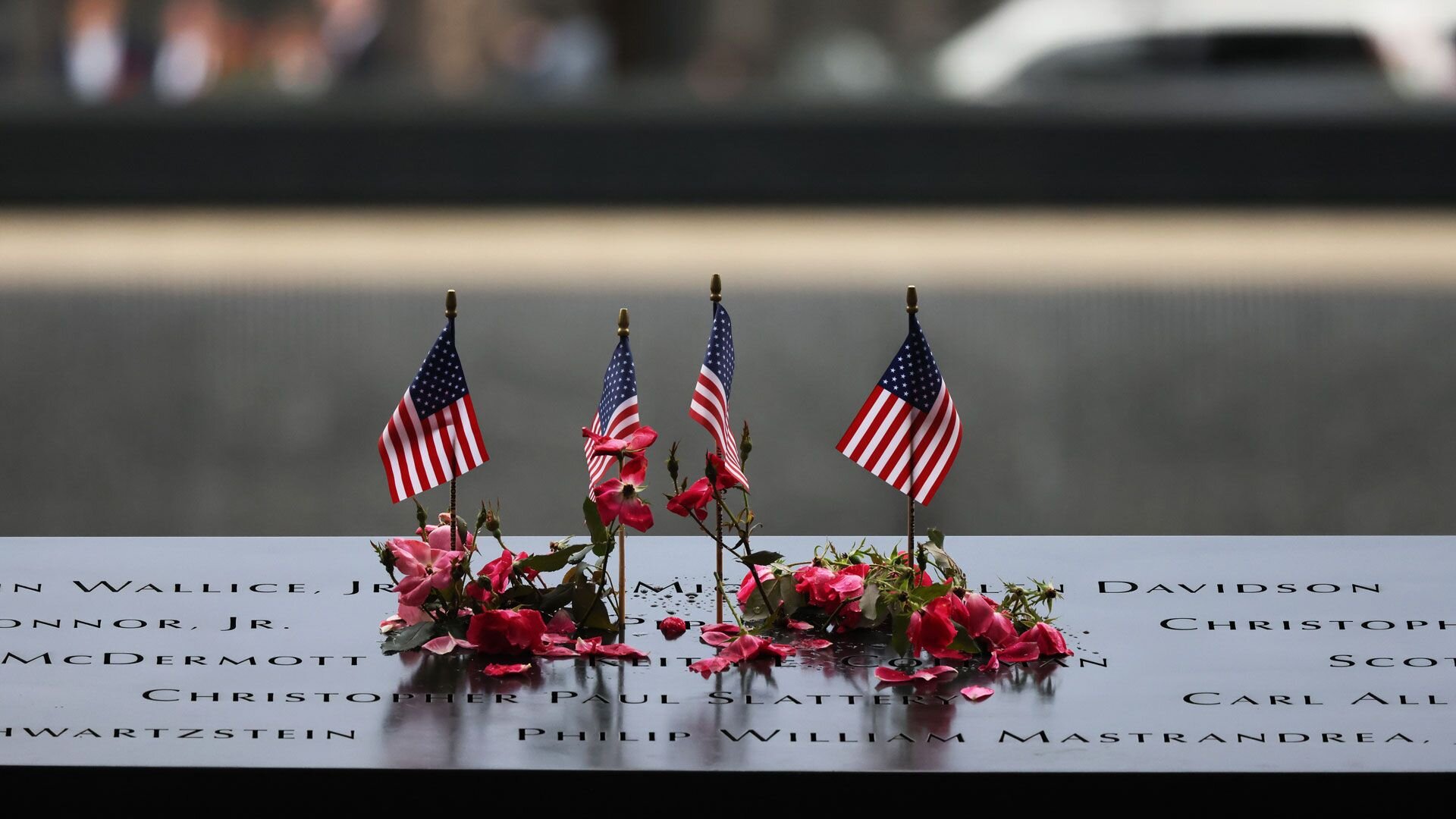 NEW YORK, NEW YORK - SEPTEMBER 11: Flowers and flags are seen on the names of the victims of the 9/11 terror attack at the North Tower Memorial Pool during the annual 9/11 Commemoration Ceremony at the National 9/11 Memorial and Museum on September 11, 2023 in New York City. Family and friends honored the lives of their loved ones on the 22nd anniversary of the terror attacks of September 11, 2001, at the World Trade Center, Shanksville, PA and the Pentagon, that killed nearly 3,000 people. (Photo by Michael M. Santiago/Getty Images)