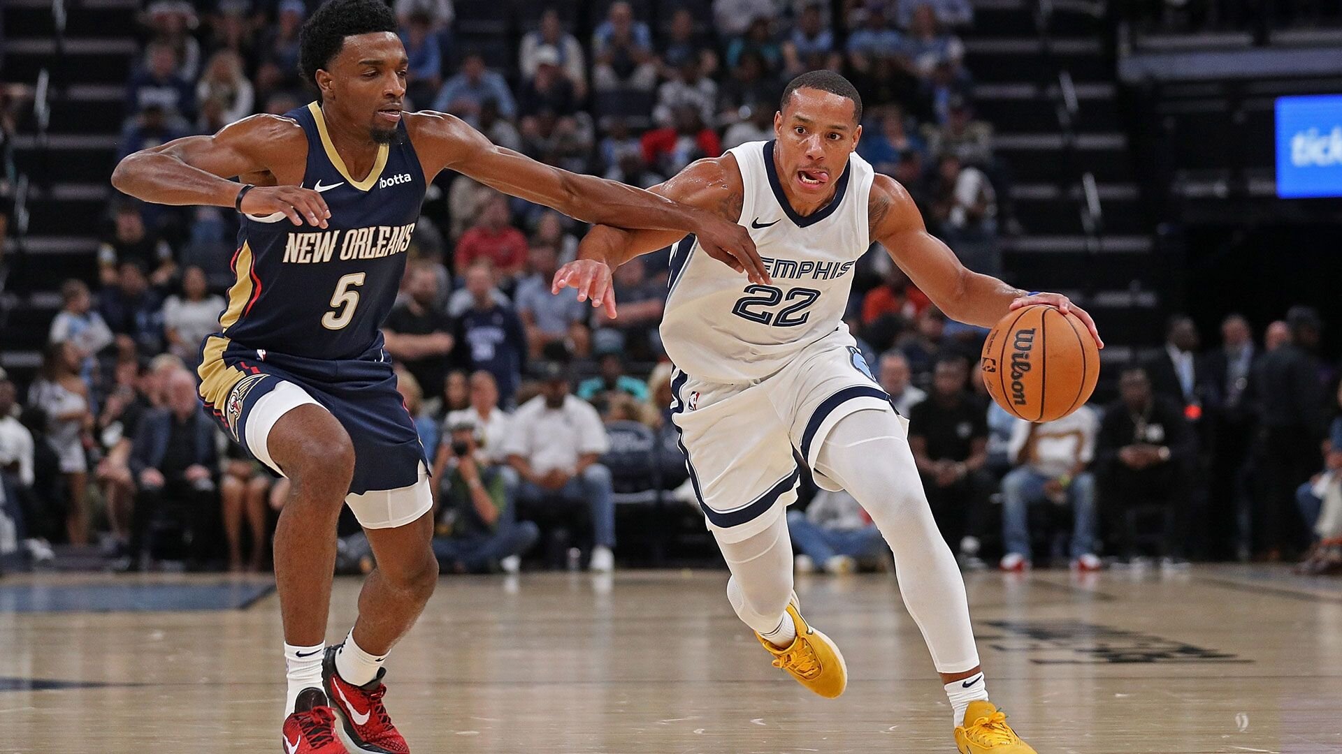 MEMPHIS, TENNESSEE - OCTOBER 25: Desmond Bane #22 of the Memphis Grizzlies handles the ball against Herbert Jones #5 of the New Orleans Pelicans during the first half at FedExForum on October 25, 2023 in Memphis, Tennessee.