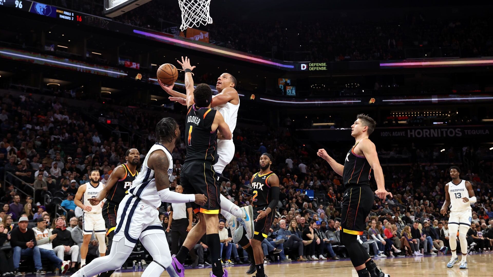 PHOENIX, ARIZONA - DECEMBER 02: Desmond Bane #22 of the Memphis Grizzlies shoots a basket against Devin Booker #1 of the Phoenix Suns during the fourth quarter at Footprint Center on December 02, 2023 in Phoenix, Arizona.