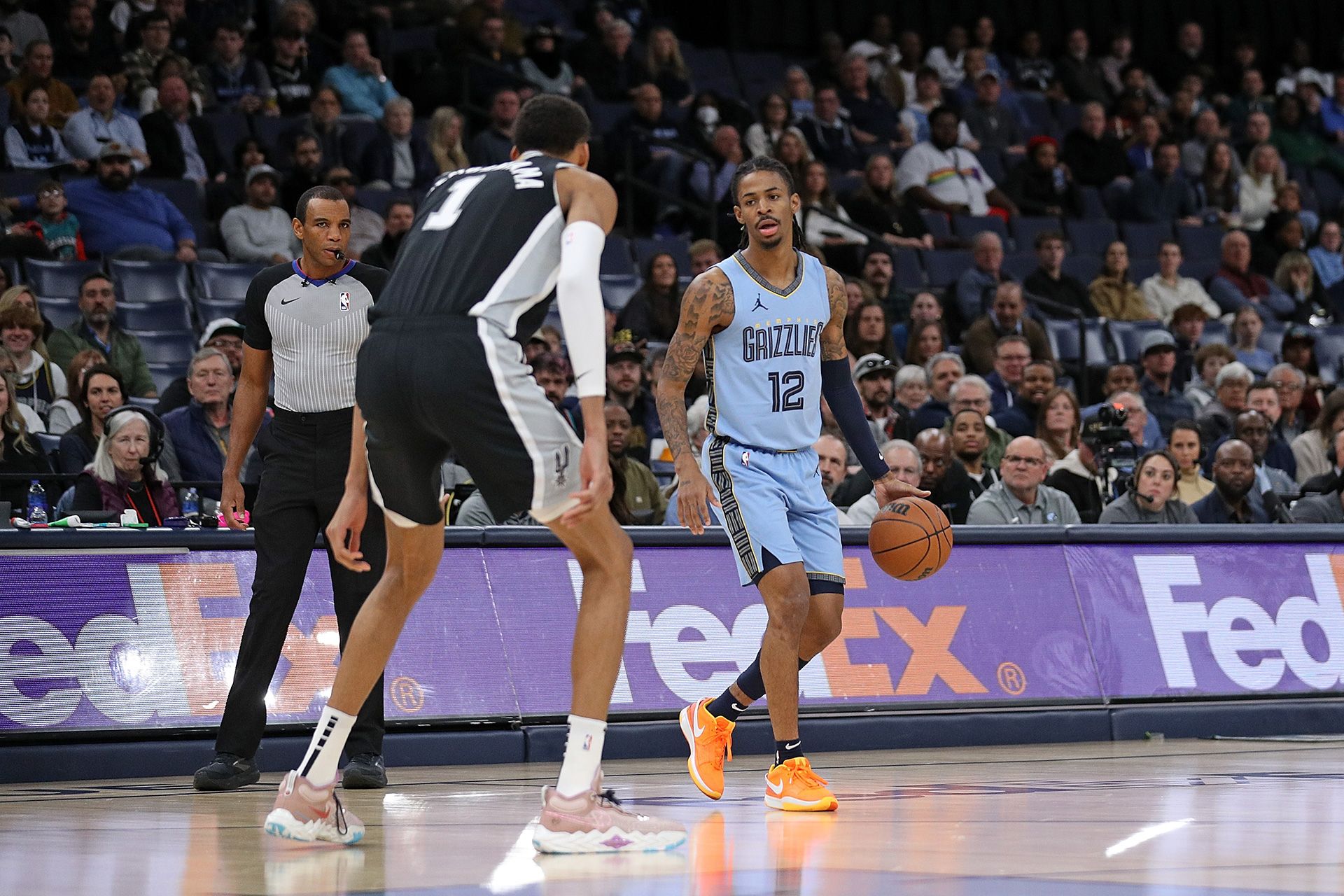 MEMPHIS, TENNESSEE - JANUARY 02: Ja Morant #12 of the Memphis Grizzlies handles the ball against Victor Wembanyama #1 of the San Antonio Spurs during the game at FedExForum on January 02, 2024 in Memphis, Tennessee.